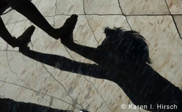 Silhouette and reflection of woman reaching out  at the Bean sculpture in Chicago