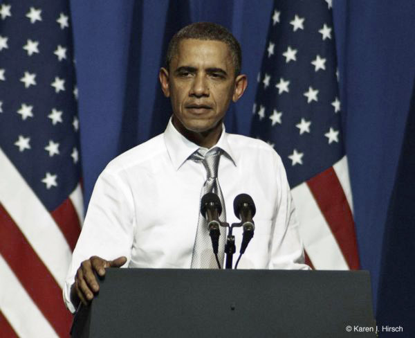 President Barack Obama at podium and American flags